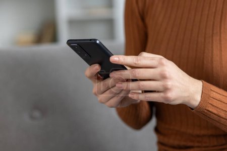 Close-up of hands holding a smartphone, likely texting or browsing. Depicts everyday technology use in a casual setting.