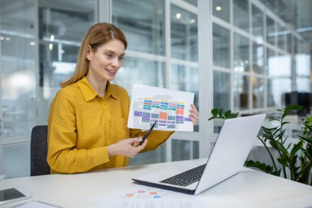A confident businesswoman in a yellow shirt presents a colorful Gantt chart during a strategic planning session in a bright office environment.