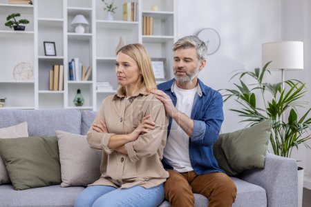 Eine aufgebrachte Frau und ein unterstützender Mann, die zu Hause über Beziehungsprobleme sprechen. Das Paar sitzt auf einer Couch in einem modernen Wohnzimmer.