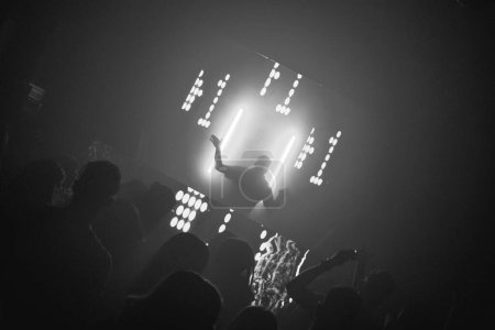 Photo for Silhouette of dj backlit while playing music in the fest - Royalty Free Image