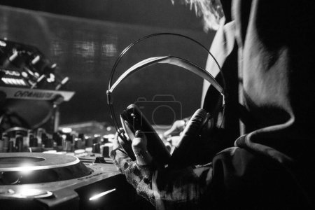 Photo for Dj hands holding headphones with console behind - Royalty Free Image