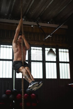 Foto de Hombre en el gimnasio haciendo cuerda de escalada - Imagen libre de derechos