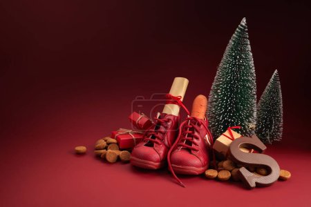San Nicolás - Día de las Sinterklaas con zapatos, zanahorias y dulces tradicionales sobre fondo rojo.