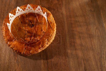 Téléchargez les photos : King cake or galette des rois in French. Epiphany pie with golden paper crown . High quality photo - en image libre de droit