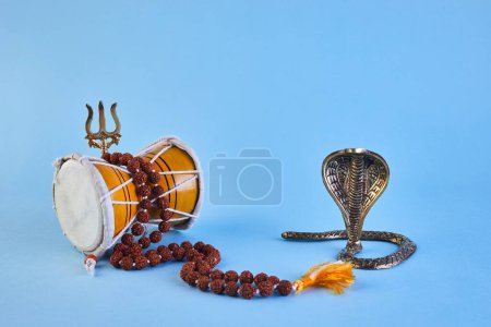 Photo for Shivaratri background with Shivas trident, Pellet Drum Damroo musical instrument ans snake . Hindu festival Maha Shivratri. - Royalty Free Image