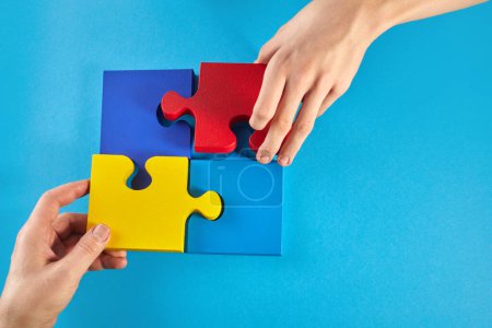 Photo for Father and autistic son hands holding jigsaw puzzle shape. Autism spectrum disorder family support concept. World Autism Awareness Day. - Royalty Free Image
