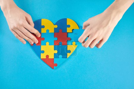 Autistic garçon mains tenant puzzle forme de coeur. Autism spectrum disorder family support concept. Journée mondiale de sensibilisation à l'autisme.