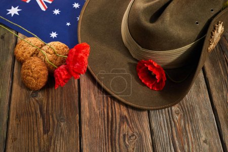Australischer Anzac-Tag. Australische Armee Schlapphut roten Mohn und traditionelle Anzac-Kekse auf hölzernem Hintergrund