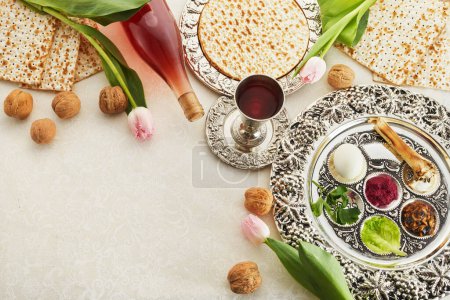 Passover Seder plate with traditional food, walnuts, matza and wine on grunge background.