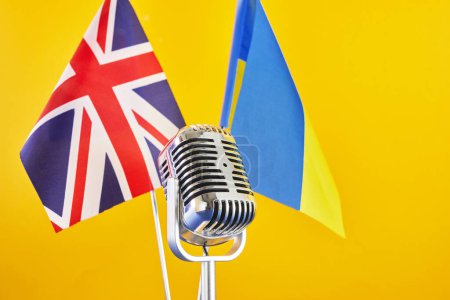 Téléchargez les photos : Microphone sur fond de drapeaux flous Ukraine et Grande-Bretagne. Concours européen de la chanson Liverpool - en image libre de droit