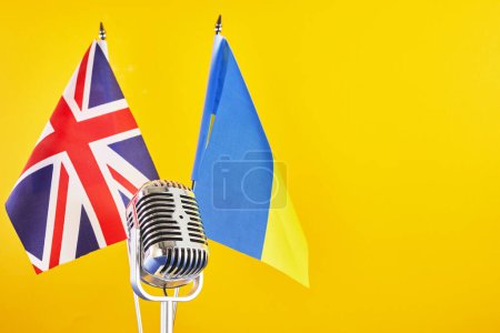 Téléchargez les photos : Microphone sur fond de drapeaux flous Ukraine et Grande-Bretagne. Concours européen de la chanson Liverpool - en image libre de droit