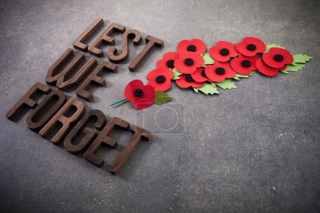 World War remembrance day. Red poppies on dark stone background. Lest we forget.