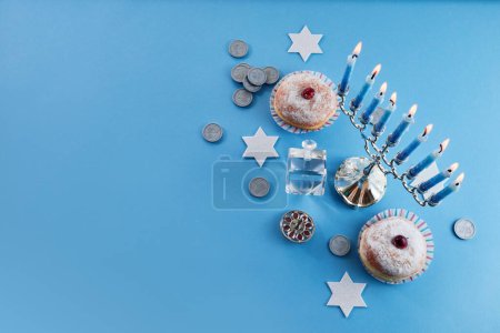 Jewish holiday Hanukkah with menorah, traditional Candelabra, donut and dreidel, spinning top