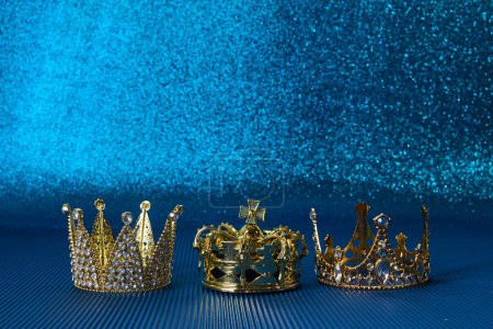 Téléchargez les photos : Epiphany Day ou concept Dia de Reyes Magos. Trois couronnes d'or sur fond bleu étincelant. - en image libre de droit
