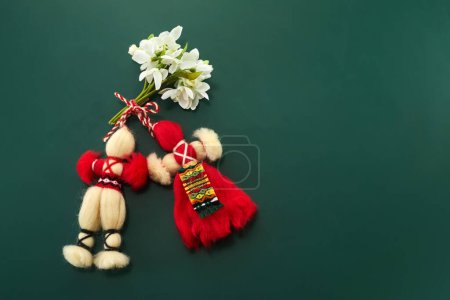A bouquet of snowdrops flowers and a red-white martenitsa, a symbol of the holiday on March 1, Martisor, Baba Marta