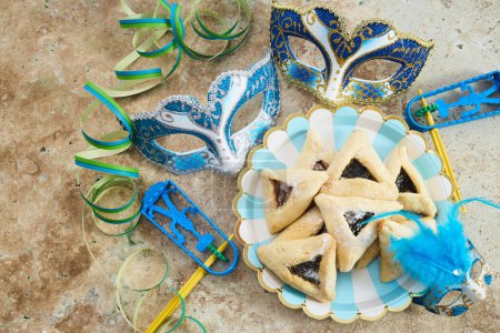 Téléchargez les photos : Vacances juives fond Pourim avec hamantaschen ou hamans oreilles biscuits, masque de carnaval et bruyant. - en image libre de droit