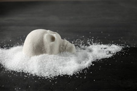 A skull-shaped sugar mound on a wooden surface symbolizing the concept of unhealthy diet.