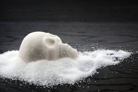 Un monticule de sucre en forme de crâne sur une surface en bois symbolisant le concept d'une alimentation malsaine.