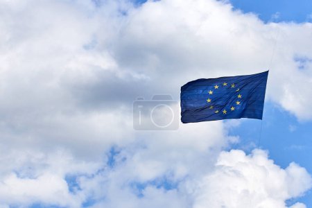 Die Flagge der Europäischen Union weht im Wind, im Hintergrund ein wolkenloser blauer Himmel