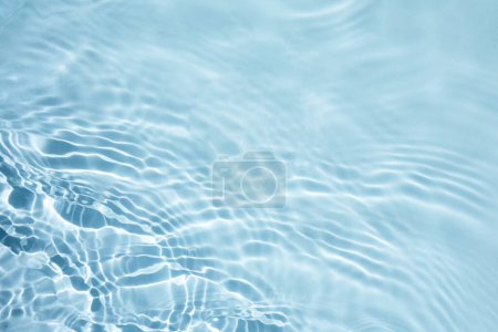 Ein ruhiger, naher Blick auf hellblaues Wasser mit sanften Wellen.