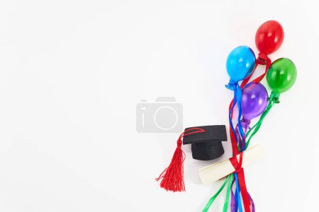Photo for Top view of graduation caps, diplomas, and colorful balloons on white. - Royalty Free Image