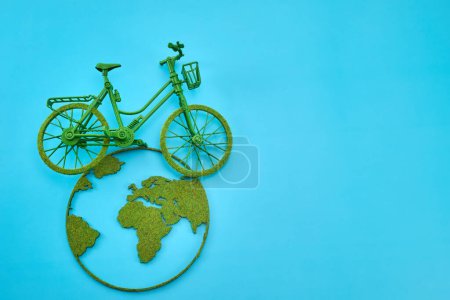 Ein Miniaturfahrrad auf einer Weltkarte, das grüne Fortbewegung symbolisiert.