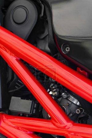 Photo for Detail of black motorcycle with red metal protector. Background - Royalty Free Image