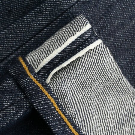 Raw denim japanese jeans lapel with white selvedge background close up