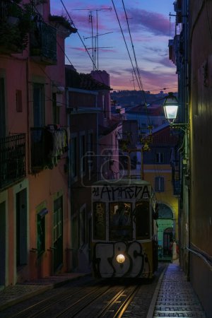 Foto de Antique yellow cable car on a narrow Portuguese street at sunset cityscape - Imagen libre de derechos
