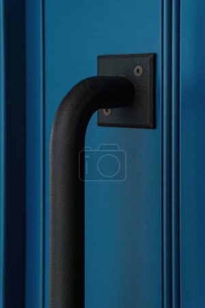 Téléchargez les photos : Grande poignée en métal noir mat sur une porte bleue close up - en image libre de droit