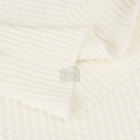Gestrickter Gummizug auf cremigem weißen Wollpullover Hintergrund Nahaufnahme