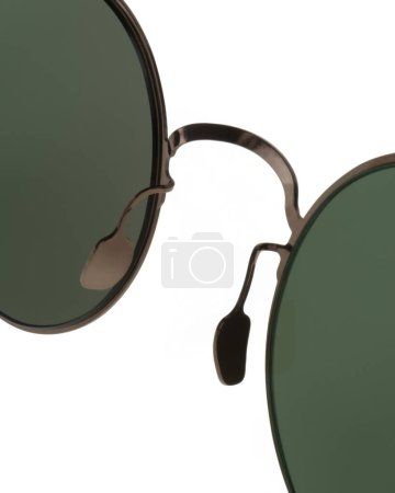 Detail of nose pad and bridge of round Panto shaped metal sunglasses with bronze frames and green lenses close up