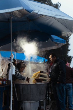 Téléchargez les photos : Fournisseur de maïs bouilli préparé et esquites sur une journée nuageuse - en image libre de droit