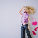 Portrait of a traditional barbie doll in a purple vest and blue jeans. Barbie Movie