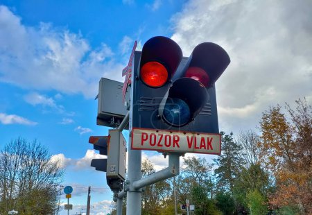 Foto de El semáforo del ferrocarril que cruza la señal de que el tren se acerca al cruce. A continuación se muestra un texto que dice en checo "Atención tren". - Imagen libre de derechos