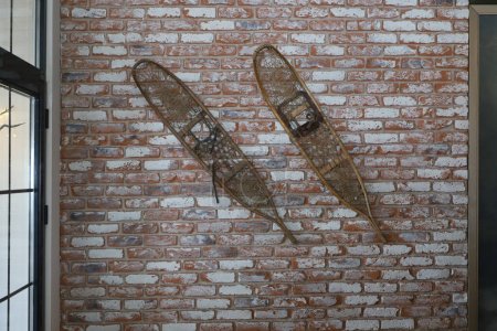 Téléchargez les photos : Un vieux hedik en bois accroché à un mur de briques, skis anciens. - en image libre de droit
