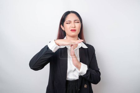 Photo for Hispanic Asian businesswoman wearing black suit doing time out gesture with hands, frustrated and serious face - Royalty Free Image