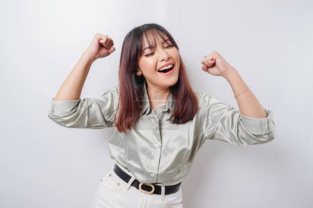 Photo for A young Asian woman with a happy successful expression wearing sage green shirt isolated by white background - Royalty Free Image