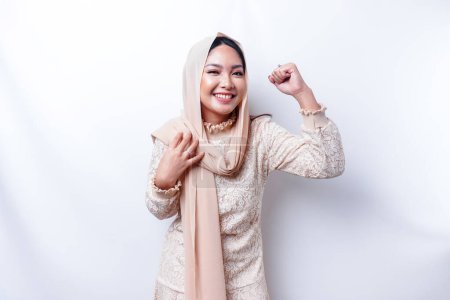 Photo for A young Asian Muslim woman with a happy successful expression wearing a hijab isolated by white background - Royalty Free Image