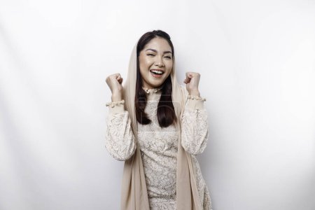 Photo for A young Asian Muslim woman with a happy successful expression wearing a hijab isolated by white background - Royalty Free Image