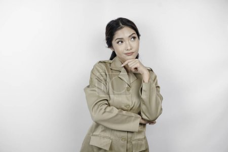 Téléchargez les photos : Confus femme ouvrière du gouvernement asiatique ont des gestes de réflexion. PNS portant un uniforme kaki. - en image libre de droit