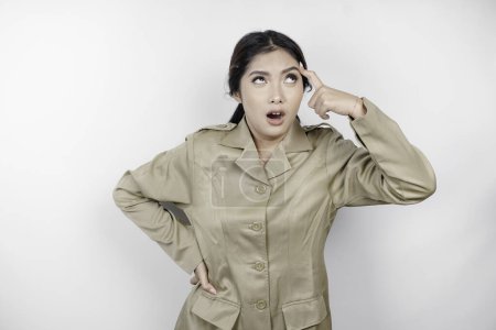 Téléchargez les photos : Fou fonctionnaire femme portant un uniforme marron se sentant tellement stressé. Employés du gouvernement indonésien concept surmené. - en image libre de droit