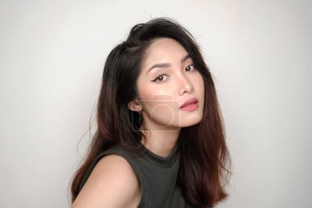 Foto de Mujer hermosa indonesia vistiendo sombra de ojos de colores en sus ojos. Piel limpia, maquillaje natural de la moda. - Imagen libre de derechos