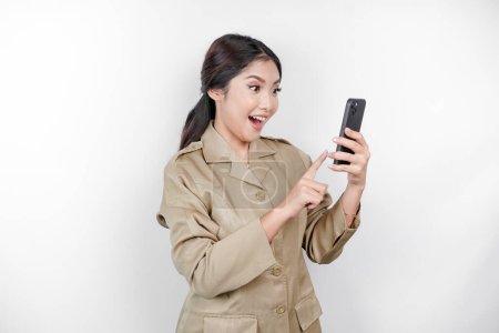 Photo for Smiling government worker woman holding her smartphone. PNS wearing khaki uniform. - Royalty Free Image