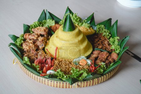 Nasi Tumpeng, Java traditional food isolated on white background. Indonesian rijsttafel of yellow rice with side dishes from several regional cuisines in the country for Independence celebration.