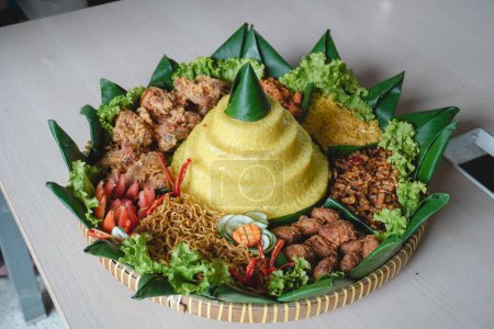 Nasi Tumpeng, Javas traditionelles Essen isoliert auf weißem Hintergrund. Indonesische Rijsttafel aus gelbem Reis mit Beilagen aus mehreren regionalen Küchen des Landes zur Unabhängigkeitsfeier.