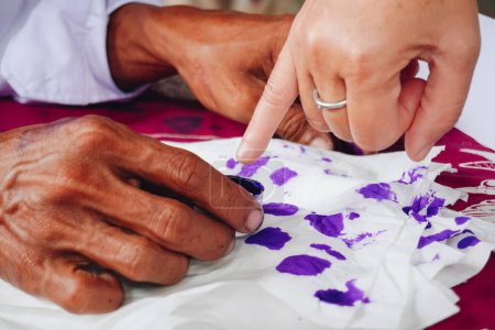 Primer retrato del dedo meñique sumergiéndose en tinta púrpura después de votar por el presidente de Indonesia y las elecciones gubernamentales 2024