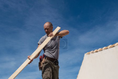 Foto de Trabajador de la construcción reparando el techo de una casa - Imagen libre de derechos