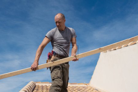 Foto de Trabajador de la construcción reparando el techo de una casa - Imagen libre de derechos
