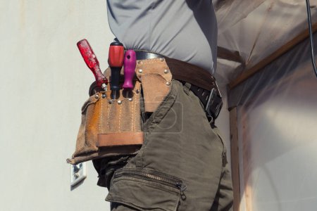 Foto de Cierre de la correa de herramientas con herramientas en el trabajador de la construcción en el trabajo. - Imagen libre de derechos